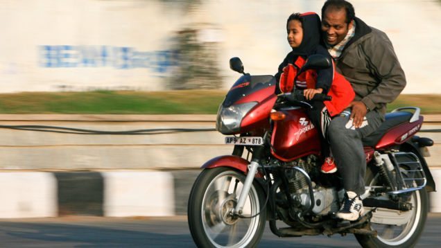 kid riding motorcycle with dad