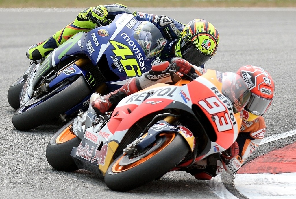 Movistar Yamaha MotoGP's Italian rider Valentino Rossi (L) chases Repsol Honda Team's Spanish rider Marc Marquez (R) during the 2015 MotoGP Malaysian Grand Prix at the Sepang International Circuit on October 25, 2015. AFP PHOTO / MANAN VATSYAYANA