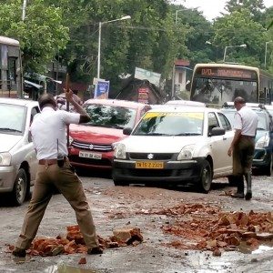 Policemen fill potholes with bricks in a rain lashed Chennai