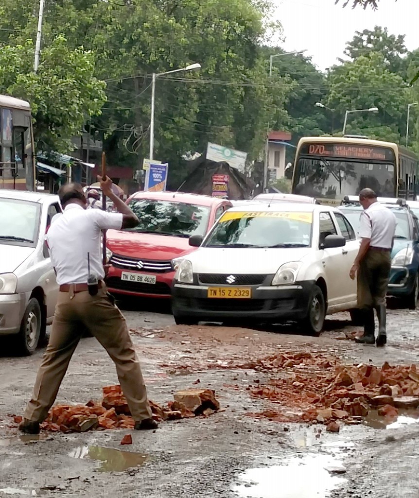 Policemen fill potholes with bricks in a rain lashed Chennai (1)