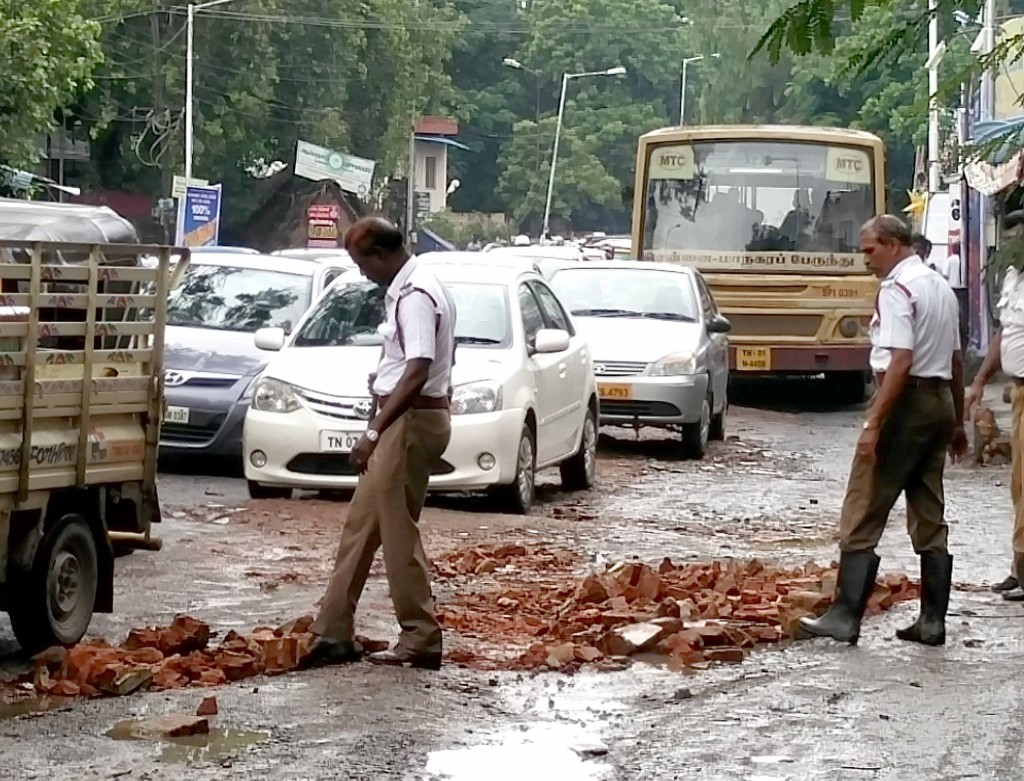Policemen fill potholes with bricks in a rain lashed Chennai (6)