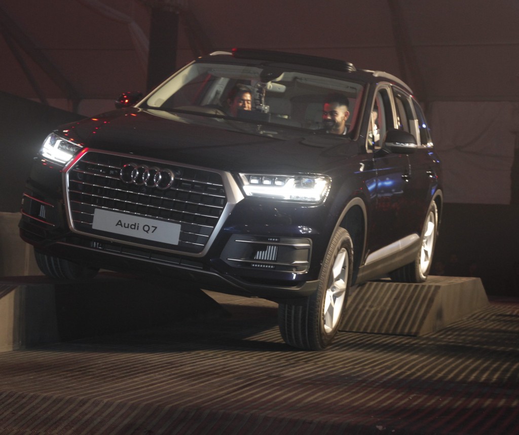 Mr. Joe King, Head, Audi India (rear seat) with Virat Kolhi, Captain of Indian Test cricket team and Audi India racing talent Aditya Patel (Driving) at the launch of new Audi Q7_1