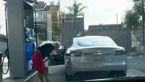 Woman takes Tesla to petrol pump fuel nozzle